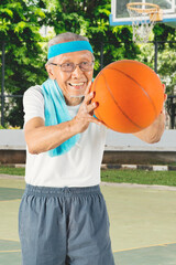 Senior man playing at the basketball court