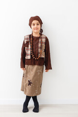 Portrait of little funny girl dressed like an old witch posing with broom in front of White background