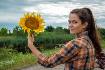 Girl with sunflower in the field
