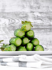Light-salted cucumbers forming a pyramid against the white background