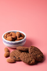 Almonds and cookies on a pink background