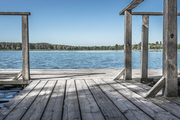 Wooden pier on the lake. Rural landscape. Place of power. The beauty of the countryside. Pacification of nature. An ideal place for meditation. Boardwalk pier for fishing.