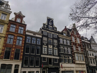 Fototapeta na wymiar Singular architecture of Amsterdam, the most famous city of Netherlands. Small and big buildings completes this wonderful urban center.