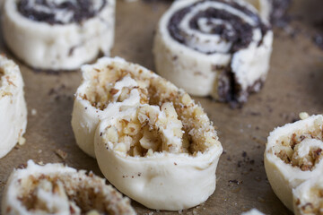 On a baking sheet are curls stuffed with poppy and walnuts. For baking.