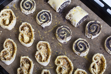 Curls stuffed with poppy and walnuts. Smeared with egg yolk. Lie on a baking sheet.