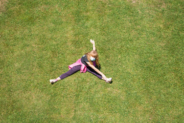 woman with medical mask doing gymnastics on the grass, new normal concept