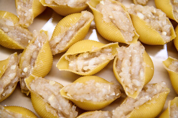 Cooking cannelloni. Stuffed pasta shells.