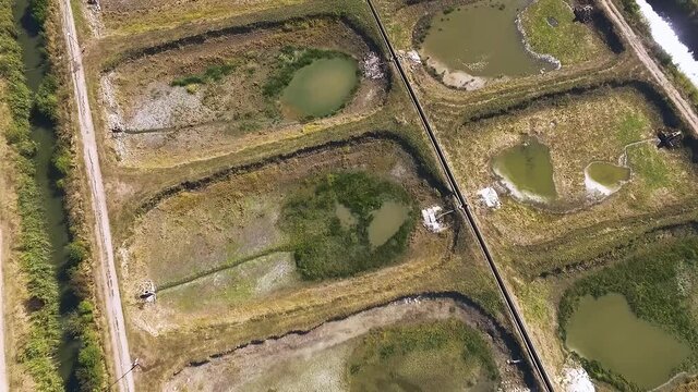 Ariel footage of empty fish farm pools on a sunny day