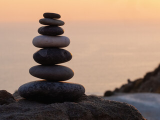 cairn at sunset, stones balances, pyramid of stones at sunset, concept of life balance, harmony and meditation