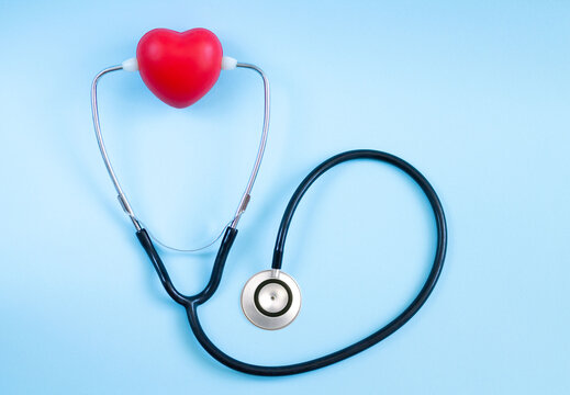 Stethoscope and red heart lying on color background. Health care, cardiology and medical concept