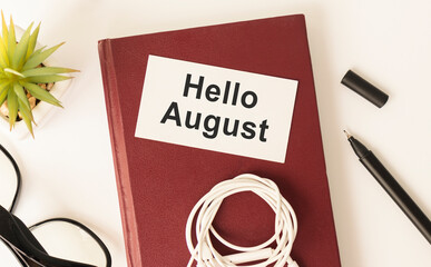 Hello August - text on a sticky note against rustic wood with a cup of coffee