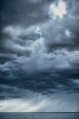 Obraz premium picturesque view of endless seascape with sunbeams reflecting on mirror water surface at cloudy day