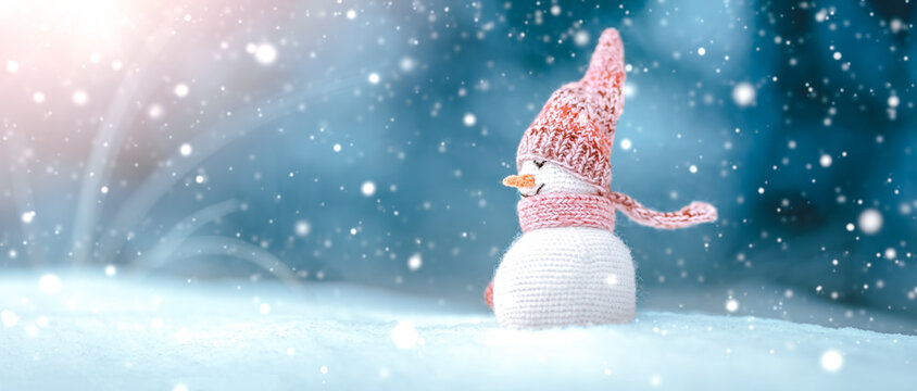 little snowman on soft snow on blue background