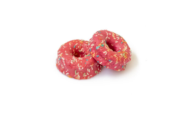 Dos donut rosa decorado con chispitas de colores aislados sobre fondo blanco.