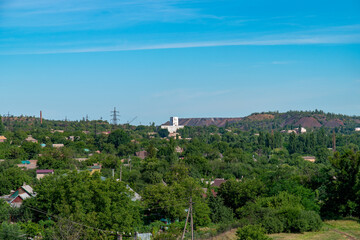 Obraz na płótnie Canvas Ukraine, Krivoy Rog, the 16 of July 2020. View on the city from the old mining dump. Country cottage area down below. 