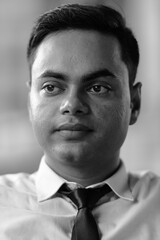 Young handsome Indian businessman in the city in black and white