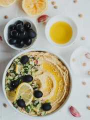 Hummus with olive oil, olives, lemon, garlic, sesame seeds, onions and cucumbers.
