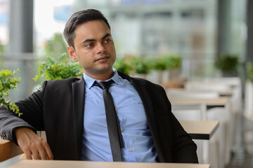 Young handsome Indian businessman in the city