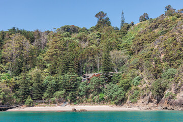 Hidden building at empty beach in Bay of Islands, New Zealand