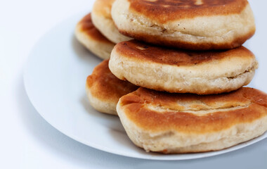 Traditional homemade fried patties or pies made of yeast dough in a rusticstyle on white plate