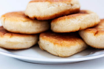 Traditional homemade fried patties or pies made of yeast dough in a rusticstyle on white plate