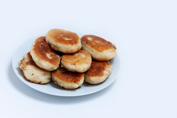 Traditional homemade fried patties or pies made of yeast dough in a rusticstyle on white plate