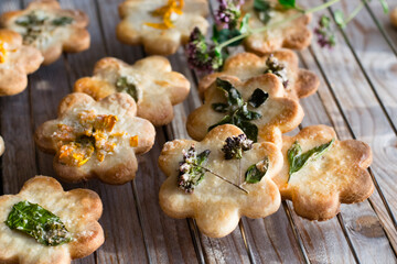 Edible flowers cookies on plate, on wooden table