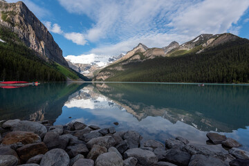 Lake Louise on a sunny day with clouds and mountains and beautiful reflections in the water