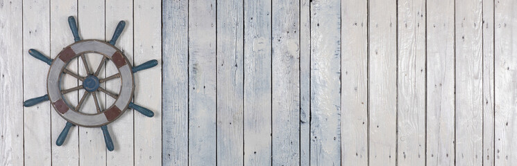 wooden steering wheel on white wooden background