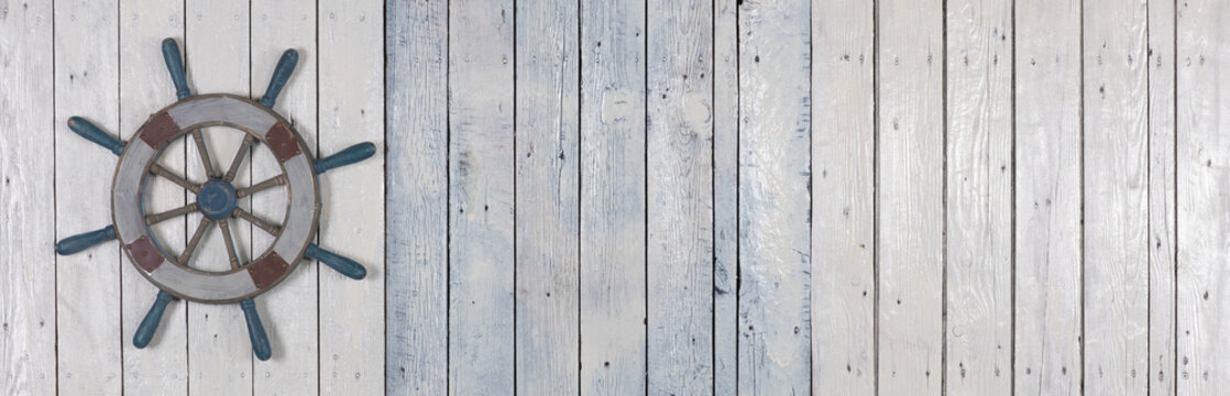 wooden steering wheel on white wooden background