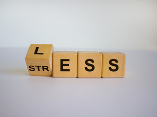 Having less stress or being stress-less. The word 'STRESS' and 'LESS' on wooden cubes. Beautiful white background, copy space.