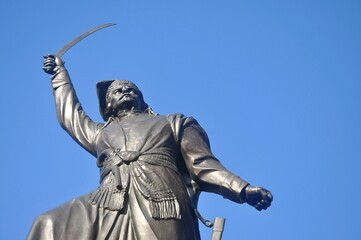 Jan Kiliński monument in Warsaw with blue sky in background.