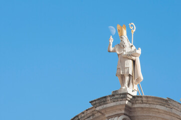 Statue on the top of saint Blaise's Church in Dubrovnik, Croatia with a moon above it's hand.