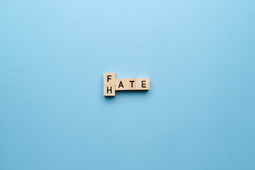 The concept of hate and fate. Letters on a blue background.