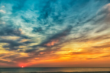 Naklejka na ściany i meble Beautiful sea sunset or sunrise with stunning clouds
