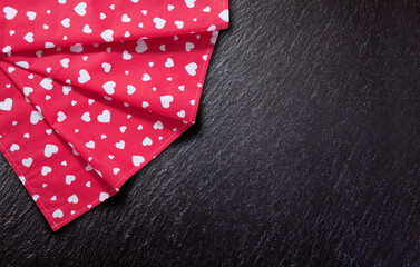 Obraz premium Red tablecloth, stone and slate on black background. Kitchen background.