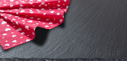 Red tablecloth, stone and slate on black background. Kitchen background.