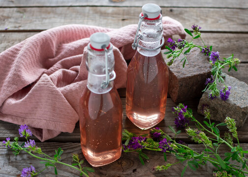 Hausgemachter Lavendelsirup in Glasflaschen mit Lavendel auf Holztisch