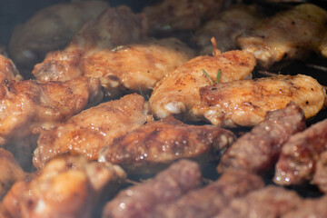 Closeup of Balkan food named cevapcici and
chicken roasted on 
barbecue. 