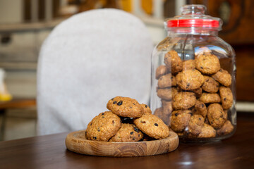oatmeal cookies with chocolate on a wooden plank. Oatmeal cookies in a glass jar