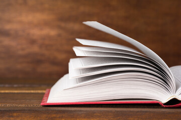 Close up of open book on old wooden background