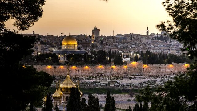 View of the Old City Jerusalem, the Temple Mount with Dome of the Rock and the Golden/Mercy Gate, through the trees of Mount of Olives, with the domes of Russian Orthodox church of Mary Magdalene