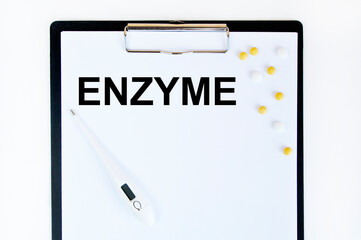ENZYME words on a blue sheet of paper against the background of multicolored tablets. Medical concept.