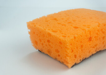 Orange sponge for washing dishes on white background
