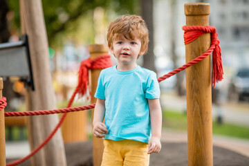 little boy of two years plays in a children's town in the summer. Children lifestyle