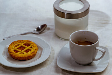 still life con taza de cafe y tarta de chocolate sobre mantel blanco