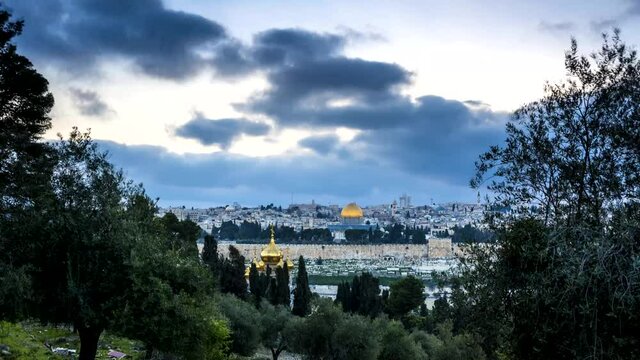 Beautiful time lapse view of Jerusalem, with dark clouds rolling over the Russian Church of Mary Magdalene, Dome of the Rock and the Golden Gate, seen from the olive grove on Mount of Olives 