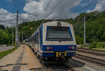 Obraz premium Payerbach-Reichenau station with electric blue old passenger unit in summer day