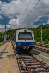 Fototapeta premium Stacja Payerbach-Reichenau z elektryczną niebieską starą jednostką pasażerską w letni dzień