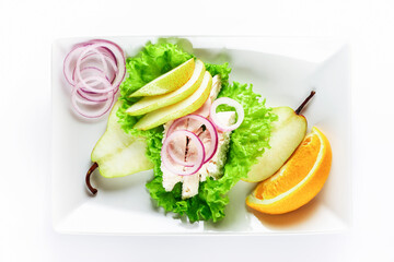 Healthy food. Chicken fillet salad with pear and orange sauce. White background. High key. Selective focus.